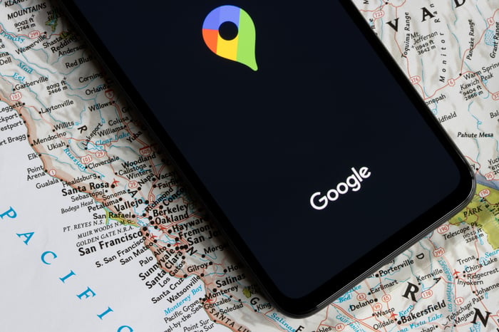 Smart phone laying on map with Google maps open for a consumers to search reviews and location information on a local business