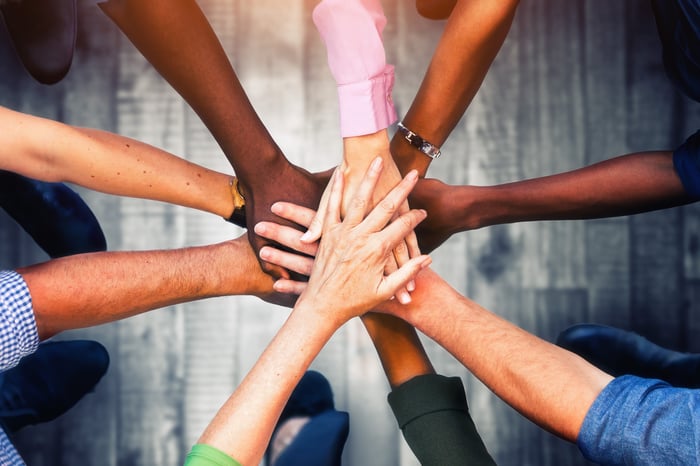 Close up view of young business people putting their hands together. Stack of hands. Unity and teamwork concept.